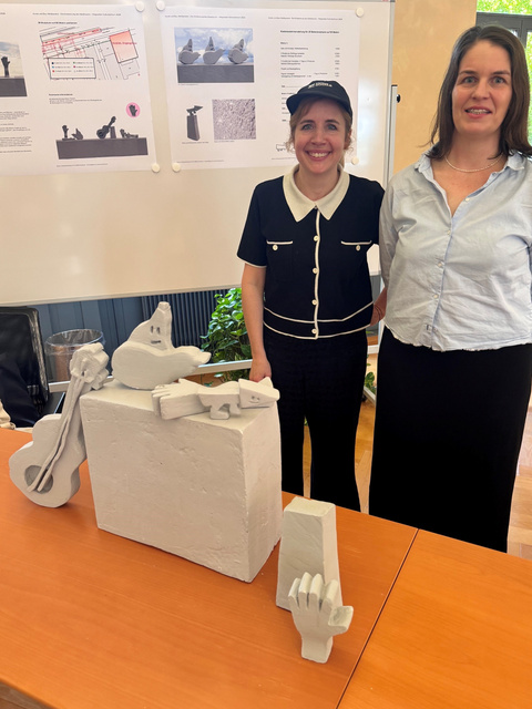 MICKRY3 mit Pl&auml;nen und Modell ihres Projektentwurfs.