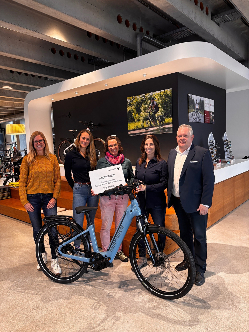 Tanja Klipfel und Maria Fattore von Tour de Suisse, flankiert von Stadtpräsident Thomas Niederberger und Martina Eggenberger vom Stadtmarketing, überreichen Beatrice Stocker den Preis. Preisübergabe